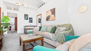 A living room with a sofa, coffee table, and artwork on the walls. - 2 Bedroom Birmingham J Quarter With Parking & Wifi (Birmingham)