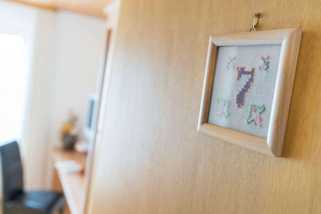 Ein gerahmtes Kreuzstichbild an der Wand.