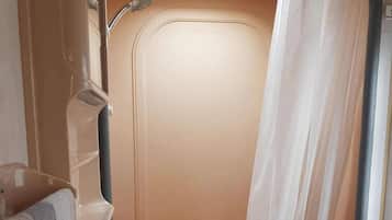 A bathroom with a shower, a towel rack, and a curtain.