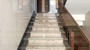 A marble staircase with a glass railing leading to a door. - Crystal Residency (Tiruchirappalli)