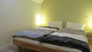 Ein Bett mit zwei Kissen, einem Holz-Kopfteil und Nachttischlampen.