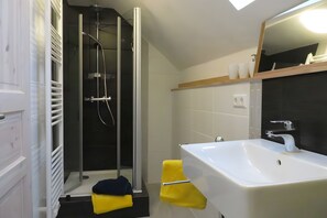 A modern bathroom with a glass-enclosed shower, a white sink, and a mirror above it. - Apartment 'Fewo Merdin' with Wi-Fi (Kappel-Grafenhausen)