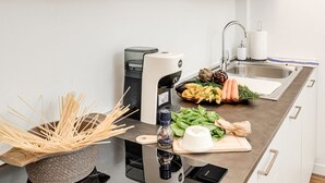 A kitchen with a modern design, featuring a stainless steel sink, a built-in coffee machine, and a variety of fresh vegetables on the counter. - Modern and cozy apartment, freshly renewed!. It features 2 fully equipped bathrooms with shower, WC, and bidet. The kitchen is brand new and fully equipped with an oven and microwave. The property includes 4 air conditioning and heating units, one in eac (Firenze)