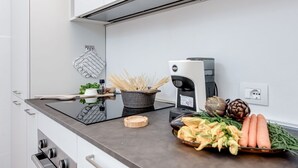 A modern kitchen with a built-in stove, a coffee maker, and fresh vegetables on the counter. - Modern and cozy apartment, freshly renewed!. It features 2 fully equipped bathrooms with shower, WC, and bidet. The kitchen is brand new and fully equipped with an oven and microwave. The property includes 4 air conditioning and heating units, one in eac (Firenze)