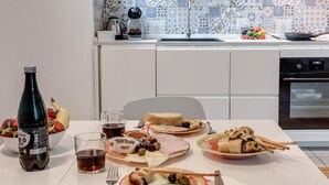 Una mesa de comedor con platos de comida, una botella y vasos.