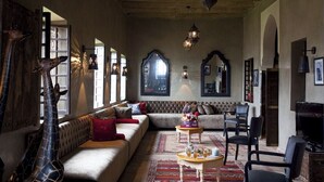A cozy living room with a sofa, chairs, a coffee table, and a television. - kasbah illy (Tifni)