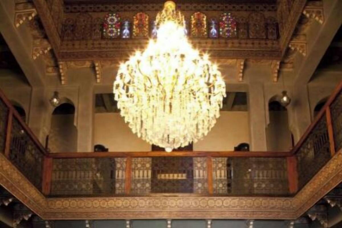 A grand hall with a large chandelier, a fountain, and ornate architecture.