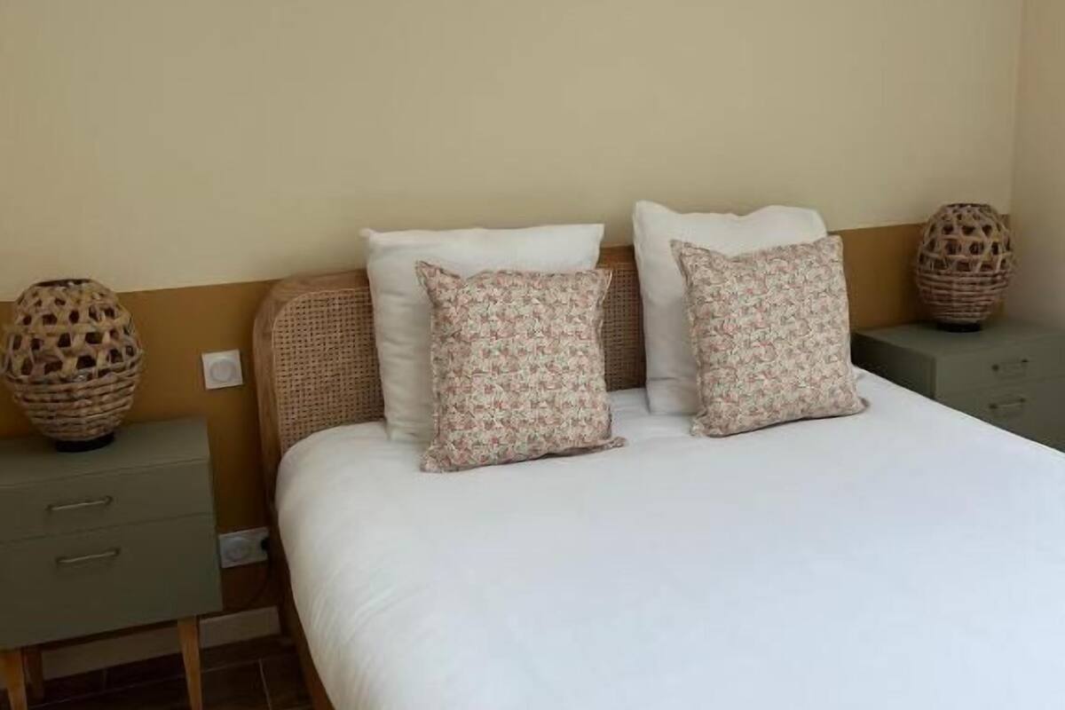 A bedroom with a large bed, two nightstands, and a woven basket on each side.