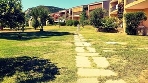 Une cour avec un chemin de pierre menant à un bâtiment doté de plusieurs balcons.