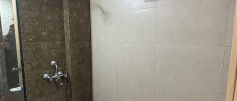 A bathroom with a shower, a towel rack, and a toilet.