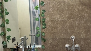 A bathroom with a mirror, sink, and shower. - Sunshine Stays, Gaur City Centre, Gr Noida West (Greater Noida)