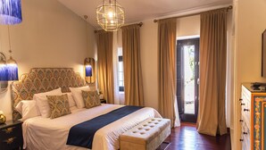 A well-appointed bedroom with a large bed, a bench, a nightstand, and a dresser. - Hotel Boutique Palacio del Moral (Ronda)