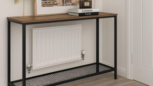 A console table with a framed picture of the Eiffel Tower, a small book titled 'LONDON,' and a reed diffuser. - Runcorn Retreat - 3 Bedroom Cozy House (Warrington)