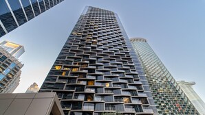 Un edificio de gran altura con una fachada distintiva que presenta un diseño de ventanas y balcones en forma de cuadrícula.