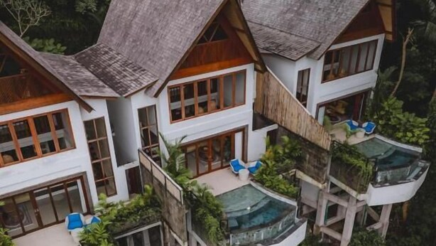 A cluster of white buildings with multiple balconies, surrounded by lush greenery. - Tempat Santai Bali (Ubud)