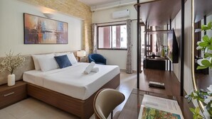 A hotel room with a bed, bedside table, chair, desk, and a large window. - Otis Apartment - 457 Rooftop Garden (Ho Chi Minh City)