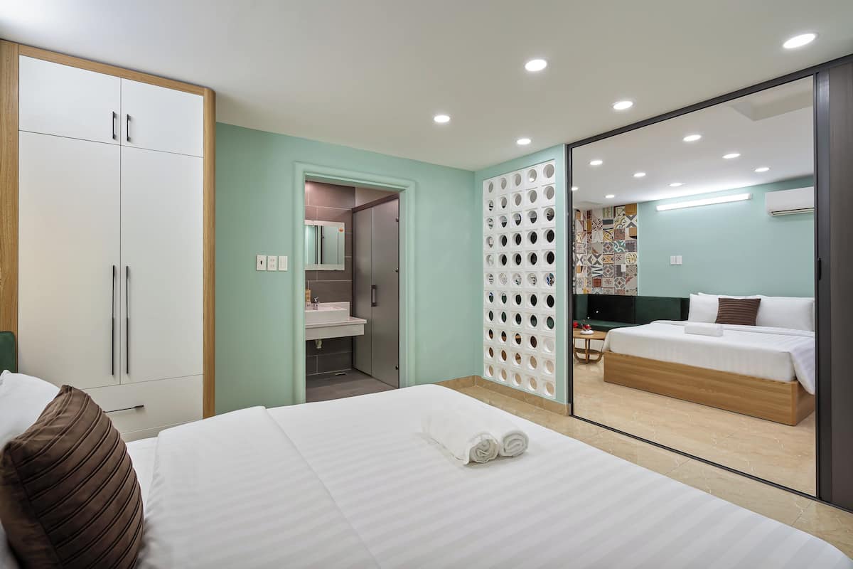 Een moderne hotelkamer met een groot bed, een kledingkast, een badkamer en uitzicht door een glazen deur.