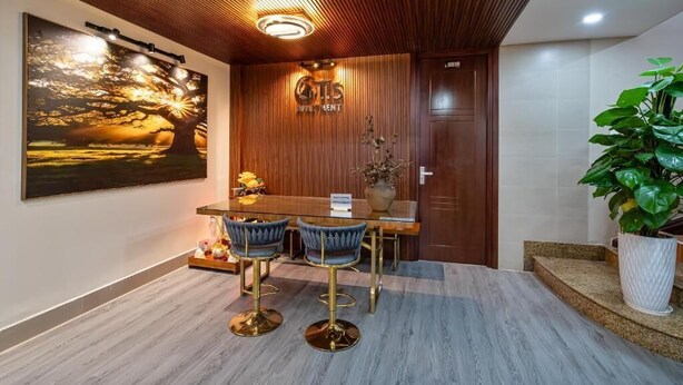 A modern interior with a wooden ceiling, a large painting, a reception desk, and a potted plant. - Otis Apartment - 457 Rooftop Garden (Ho Chi Minh City)
