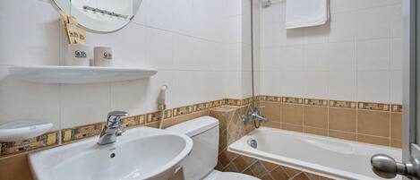 A bathroom with a sink, toilet, and bathtub.