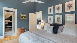 A bedroom with a bed, a ceiling fan, a wardrobe, and framed artwork on the wall. - Watersound Resort, Coastal Charm, Walk To Beach! (Inlet Beach)