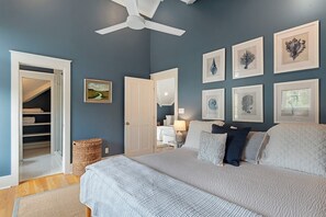 A bedroom with a bed, a ceiling fan, a wardrobe, and framed artwork on the wall. - Watersound Resort, Coastal Charm, Walk To Beach! (Inlet Beach)