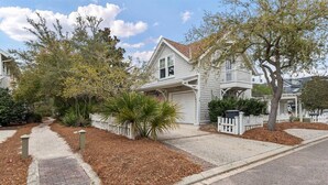 A residential house with a front yard, driveway, and a white picket fence. - Watersound Resort, Coastal Charm, Walk To Beach! (Inlet Beach)