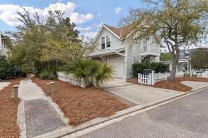 A residential house with a front yard, driveway, and a white picket fence. - Watersound Resort, Coastal Charm, Walk To Beach! (Inlet Beach)