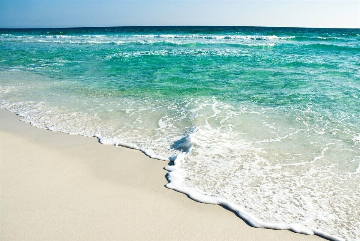 A beach with clear turquoise water and white sand.
