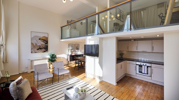 A modern apartment with a living room, dining area, kitchen, and a glass balcony. - St Gabriel's Loft Apartment (London)
