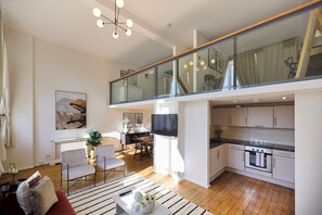 Un apartament modern amb saló, menjador, cuina i un balcó de vidre.