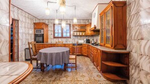 Una cucina con un tavolo rotondo, mobili in legno e un pavimento decorato.