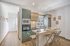Eine moderne Küche mit einer zentralen Kochinsel, einer Mikrowelle, einem Backofen und einem Spülbecken.