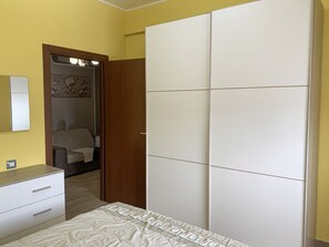 A bedroom with a bed, a wardrobe, a dresser, and a mirror. - Mariposa - Villaputzu (Villaputzu)
