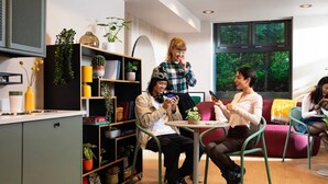 Un interior moderno con zona de cocina, mesa de comedor y arreglos de asientos.