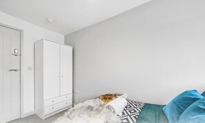 Ein Schlafzimmer mit Bett, Kleiderschrank und Tür.