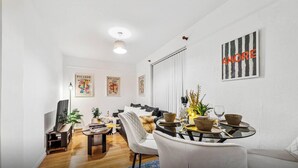 Uma sala de estar moderna com um sofá, mesa de centro e obras de arte nas paredes.
