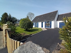 A residential property with a paved driveway, a well-maintained lawn, and a large tree. - Single-storey house with enclosed garden (Crozon)