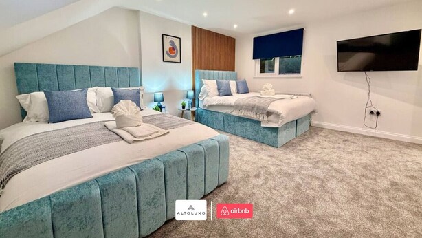 A modern hotel room with two beds, a flat-screen TV, and a view of the city. - Available Now|Luxury|Contractors|Families|Groups (Easton)