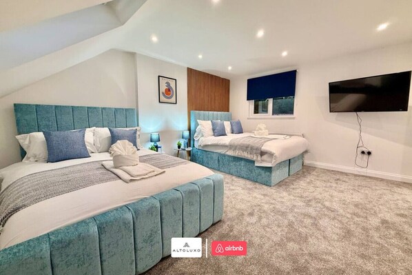 A modern hotel room with two beds, a flat-screen TV, and a view of the city. - Available Now|Luxury|Contractors|Families|Groups (Easton)