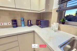 A modern kitchen with a countertop, cabinets, a sink, and a window with a view. - Available Now|Luxury|Contractors|Families|Groups (Easton)