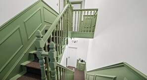 Eine Treppe mit grünen Geländern und einem Teppichbelag.