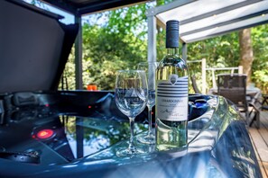 A car interior with a bottle of wine and two glasses on the dashboard. - Boshuisje met jacuzzi (Lanaken)