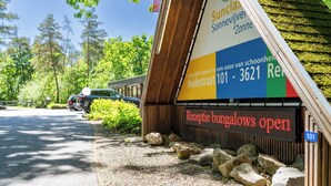 A reception sign for a bungalow with a contact number and a location address. - Boshuisje met jacuzzi (Lanaken)