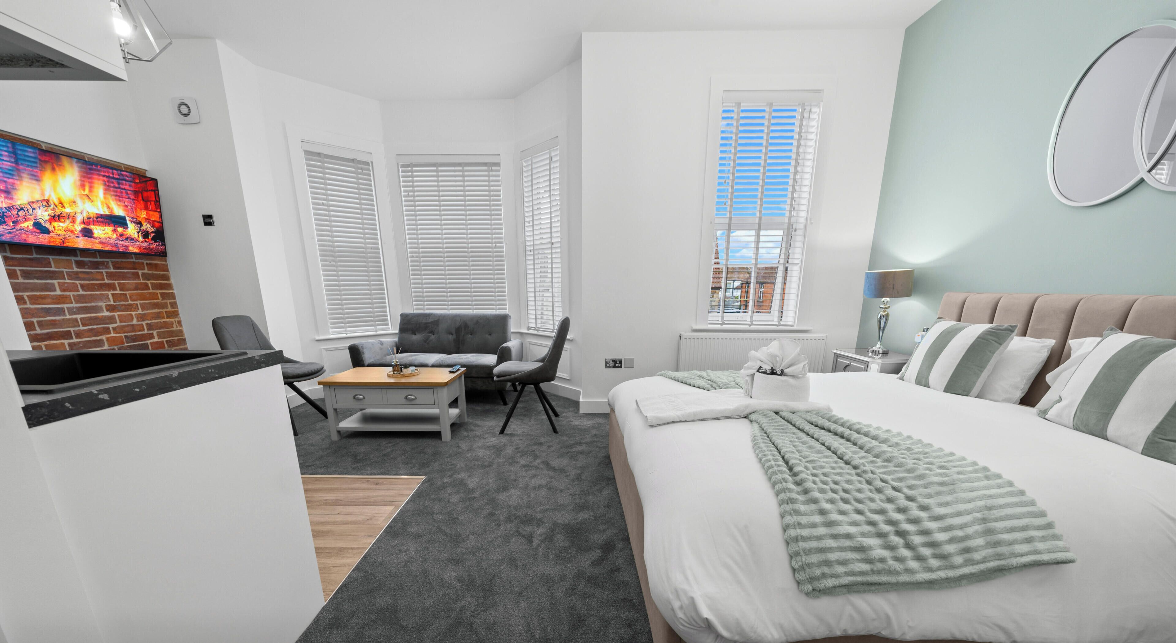 Une chambre d’hôtel équipée d’un lit, d’un bureau, d’une chaise, d’une télévision et d’une fenêtre avec des stores.