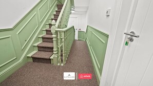 A staircase with green walls and carpeted steps leading to a door with a key lock. - Burnham-on-sea | Luxury | Families | Large Groups (Somerset)