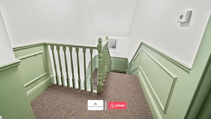 A staircase with green railings and a carpeted landing. - Burnham-on-sea | Luxury | Families | Large Groups (Somerset)