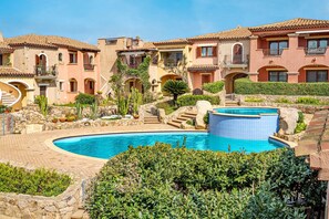 Un resort con piscina, edificios de varios pisos y un camino de piedra.
