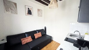 Eine moderne Küche mit einem schwarzen Sofa und einer Fernbedienung auf der Arbeitsfläche.