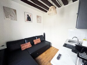 A modern kitchen with a sink, countertop, and a remote control on the counter. - Urban Flat 164 - Cosy Studio in Paris Saint Martin (París)