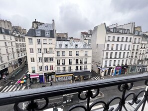 Blick auf eine Stadtstraße mit Gebäuden, einer Fußgängerampel und einem Fußgänger.